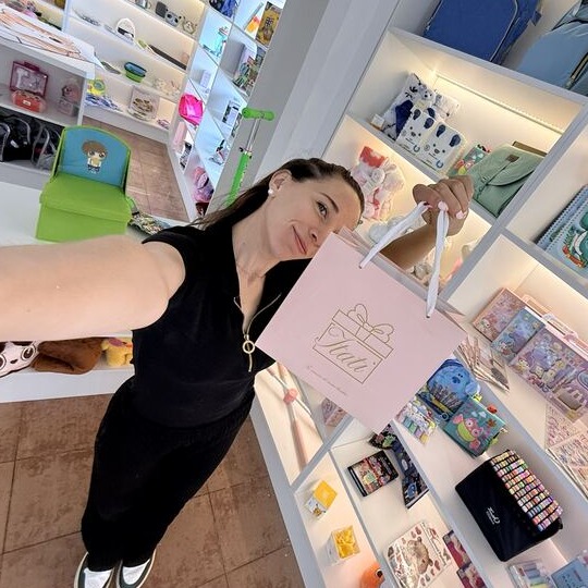 Itati, dueña de ITATI regalería, en su local de Neuquén Capital sosteniendo una bolsa de regalo